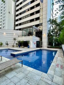 uma piscina em frente a um edifício em Flat no hotel Q. Paulista nos Jardins, com sacada! em São Paulo