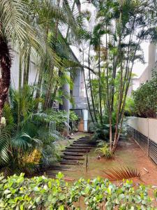um grupo de palmeiras e escadas em frente a um edifício em Flat no hotel Q. Paulista nos Jardins, com sacada! em São Paulo