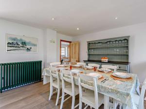 uma sala de jantar com uma mesa e cadeiras brancas em 4 Bed in Lulworth Cove DC176 em West Lulworth