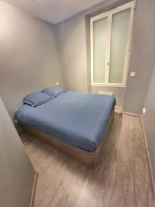 a bedroom with a blue bed in a room at (Nouvelles literie)ménage gratuit in Bayonne