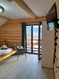 a bedroom with a bed and a chair and a television at CABANA BELVEDERE in Borşa