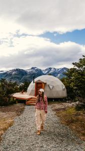 Eine Frau, die vor einem Zelt eine Schotterstraße hinuntergeht. in der Unterkunft Estancia Patagonia El Calafate - Pristine Luxury Camps in El Calafate