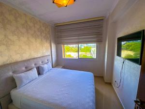 a bedroom with a white bed and a window at LovelyStay - Luxury & proximity to Corniche and TGV in Tangier