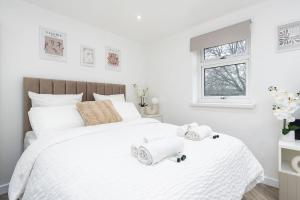 a bedroom with a white bed with towels on it at Modern 1 Bed Studio Flat Leeds in Headingley