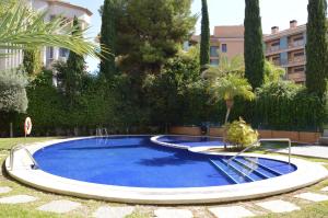 uma grande piscina azul num quintal com árvores em Albir Beach & Sea Apt em Albir