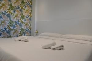 a white bed with two towels on top of it at Albir Beach & Sea Apt in Albir