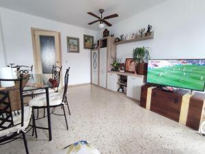 ein Wohnzimmer mit einem Flachbild-TV und einem Tisch in der Unterkunft Habitación Privada Juan in Estepona