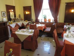 ウィーンにあるホテル ペンション シュタットパークのテーブルと椅子が備わるレストラン