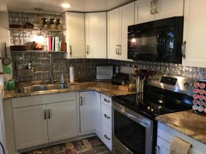 a kitchen with white cabinets and a sink and a stove at The Charleston Inn Hendersonville NC in Hendersonville