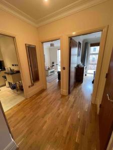 uma sala de estar vazia com pisos de madeira e dois espelhos em Entire 1 bed apartment-Convenient and peaceful amenable stay em Londres