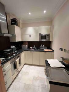 a large kitchen with white cabinets and appliances at Entire 1 bed apartment-Convenient and peaceful amenable stay in London