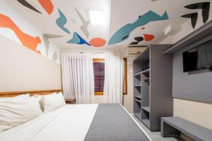 a bedroom with a bed and a tv on the ceiling at Bossa Jurerê Hotel in Florianópolis