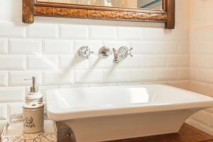 a bathroom with a white sink and a mirror at B&B Antico Telaio in Santa Maria Navarrese