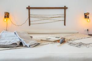 a bed with a cross hanging on the wall at B&B Antico Telaio in Santa Maria Navarrese