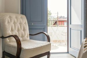 a chair sitting in front of a window at B&B Antico Telaio in Santa Maria Navarrese