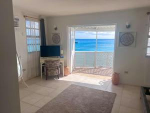 una sala de estar con una puerta abierta al océano en Purple Rain - Direct Beach Access, 2 Bedroom, 2 Terrace Holiday Home Bliss en Saint Peter