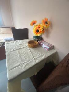 Dimitris Rooms في Asvestokhórion: طاولة عليها إناء من الزهور