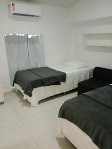 dwa łóżka w białym pokoju bez w obiekcie Flats Ancorar w mieście Porto de Galinhas