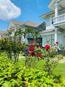 a house with red roses in the yard at Sealink Beach Villa PE48- PE69 in Ấp Bình Hưng