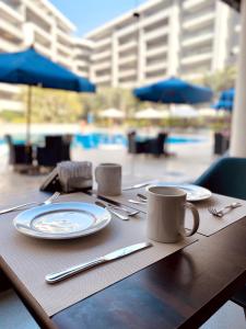 a wooden table with plates and utensils on top of it at Ocean Blue Studios in Cairo