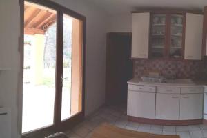 eine Küche mit weißen Schränken, einem Waschbecken und einem Fenster in der Unterkunft maison le Rossignol in Châtillon-en-Diois