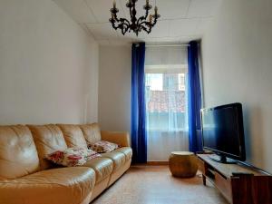 - un salon avec un canapé et une télévision dans l'établissement La Casa sulle Mura - Montecarlo - A 15 km da Lucca, à Montecarlo