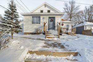 a house in the snow with a driveway at Charming Crookston Home Walk to Downtown! in Crookston