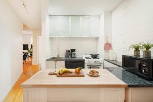 une cuisine avec un comptoir et une banane sur une planche de coupe dans l'établissement 139-2W Prime west village Furnished 2BR Best value, à New York
