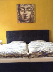 a bed with a picture of a head on the wall at Ferienwohnungen Jakobsberg in Bamberg