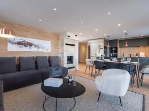 a living room with a couch and chairs and a kitchen at Appartement Courchevel 1650, 5 pièces, 8 personnes - FR-1-563-136 in Courchevel