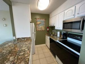 a kitchen with white cabinets and granite counter tops at Bikinis and Martinis at Dolphin Run-Oceanfront-Pool! in Virginia Beach
