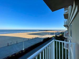a view of the beach from the balcony of a condo at Bikinis and Martinis at Dolphin Run-Oceanfront-Pool! in Virginia Beach