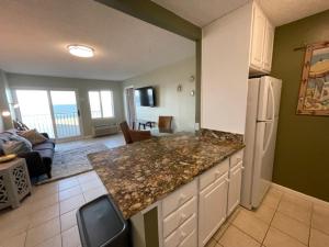 a kitchen with a counter top and a living room at Bikinis and Martinis at Dolphin Run-Oceanfront-Pool! in Virginia Beach