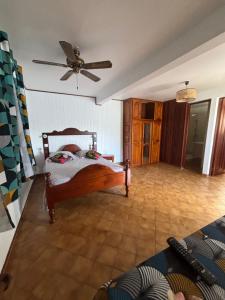 ein Schlafzimmer mit Bett und Deckenventilator in der Unterkunft Résidence la perle in Deshaies