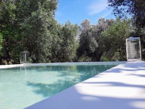 una piscina con árboles en el fondo en Casa Trullo Bianco: Casa Limone, en Ceglie Messapica
