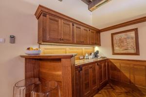 a kitchen with wooden cabinets and a counter with stools at Traditional Prague Apartment in Prague
