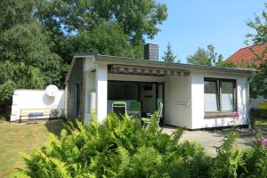 ein kleines weißes Haus mit Garten in der Unterkunft Sonne in Elmenhorst