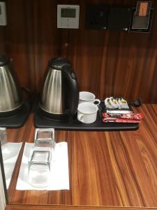 a tray with a tea kettle and cups on a table at The Capital Heart Hotel in Baghdād