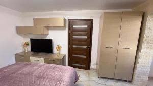 a bedroom with a bed and a desk with a television at LA DENIS LUPENI ! Apartament cu 1 camera! in Lupeni
