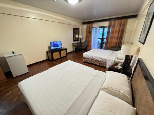 a hotel room with two beds and a television at Alta Vista De Boracay Hymettus 109 in Boracay