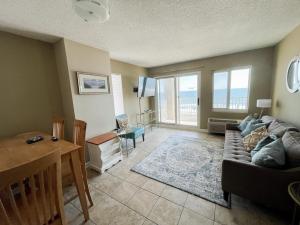 a living room with a couch and a table at Playing Hooky at Dolphin Run-Oceanfront Condo-Pool in Virginia Beach