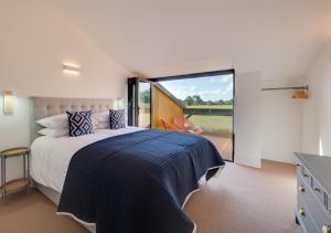 1 dormitorio con cama grande y ventana grande en No.2 Long Barn, en Wangford