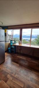 a kitchen with a table and a large window at Cabaña Puerto Williams in Puerto Williams