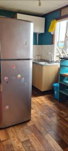 a kitchen with a stainless steel refrigerator and a sink at Cabaña Puerto Williams in Puerto Williams