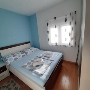 - une chambre avec un lit aux murs bleus et une fenêtre dans l'établissement Große Wohnung in Podstrana mit Eigenem Balkon, à Podstrana