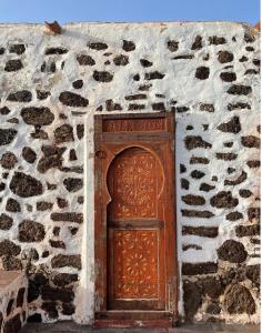 a wooden door in a stone wall at Casa Cocolores in Villaverde