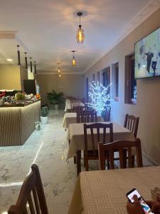 a restaurant with tables and chairs and a christmas tree at Bujtina ALDOR in Berat