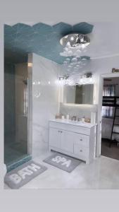 a bathroom with a shower and a sink and a mirror at Ocean Haus in Portsmouth