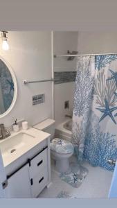 a bathroom with a toilet and a shower curtain at Ocean Haus in Portsmouth