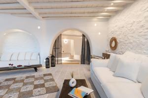 a living room with a white couch and a table at White Stone Mykonos in Agios Ioannis Mykonos